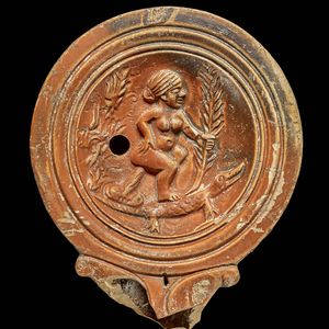 Roman lamp with a caricature of Cleopatra,depicted naked and sitting on a phallus on the back of a crocodile. Late 1st century BC-Early 1st century AD