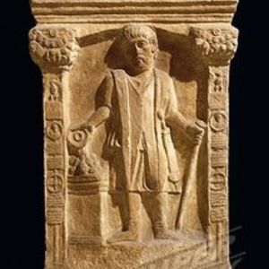 Roman funerary relief of a soldier with a cloak and vine rod. Previously labelled a centurion conducting a rite; the action is not established by the image alone.