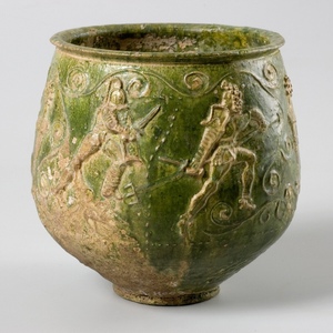 Roman glass with green glaze, decorated with scenes of gladiatorial fights, here secutor and retiarius: circa 2nd century AD
