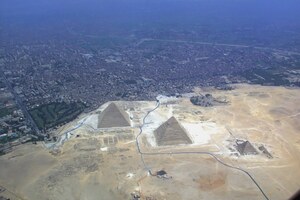 Giza pyramid complex from the air: pyramids of Khufu, Khafre and Menkaure, causeways, temples and cemeteries on the plateau.