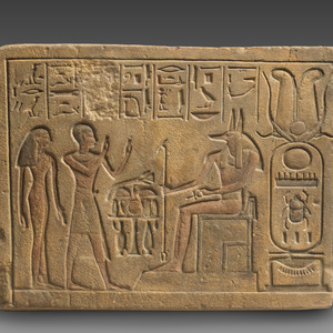 Relief showing a priest and a woman worshipping Anubis. New Kingdom, Dynasty 18, reign of Thutmose IV, ca. 1400-1390 BC; sandstone, paint. The Metropolitan Museum of Art, 90.6.128.