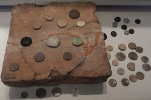Floor tile incised as a game board with bone counters from Calleva Atrebatum, Silchester. Reading Museum.