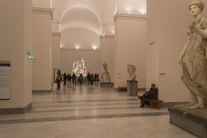 A MANN gallery with large ancient sculpture; the Farnese Bull group is visible in the background.