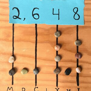 Современная гипотетическая схема счётной доски с камешками-calculi. Она показывает разрядный принцип, но не воспроизводит конкретную античную находку и не доказывает единственный римский алгоритм. Автор Jacobolus / Wikimedia Commons, CC BY-SA 4.0.