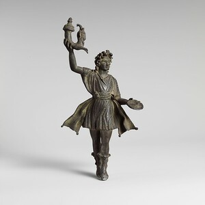Бронзовая статуэтка лара, I–II века н. э. Домашний бог изображен с ритоном и патерой — сосудами для питья и возлияния. Метрополитен-музей, инв. 19.192.3. Public Domain. Источник: https://www.metmuseum.org/art/collection/search/250737