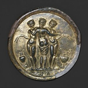 Gilded bronze mirror with the Three Graces, mid-2nd century CE; bronze, silver, gold and speculum alloy, diameter 12.1 cm. The mythological subject turned a toilet article into an image and also circulated in sculpture and mosaic. The Metropolitan Museum of Art, acc. 1987.11.1. Public Domain.